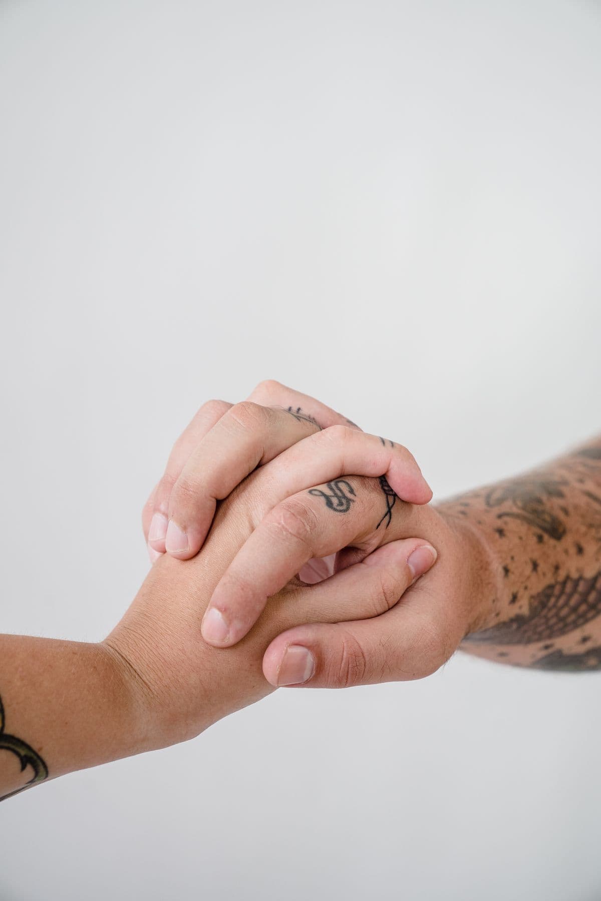 Two tattooed hands intertwined